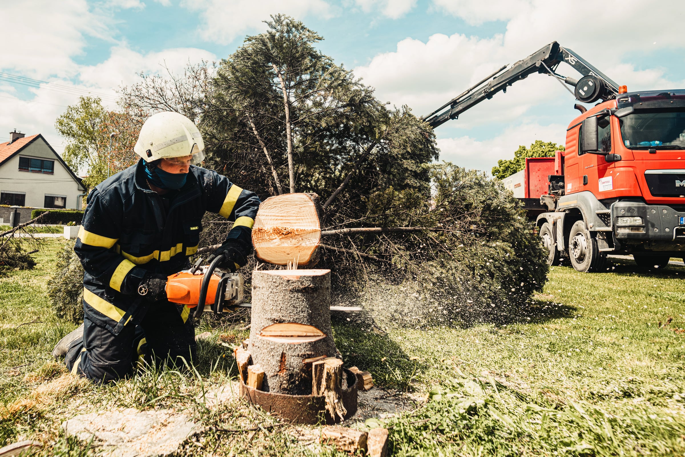 Worker using a chainsaw on a tree stump during land clearing work